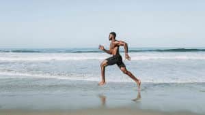 Man Running Barefoot on Beach