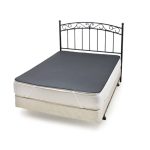 A metal bed frame with a decorative headboard supports an Earthing Elite Super King Size Mattress Cover over the mattress, topped by a dark fitted sheet and with a light-colored box spring beneath.